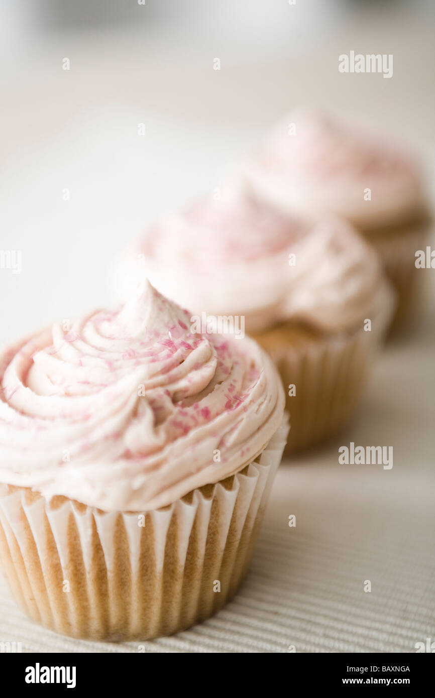 Three pink cupcakes, ready to eat. Stock Photo