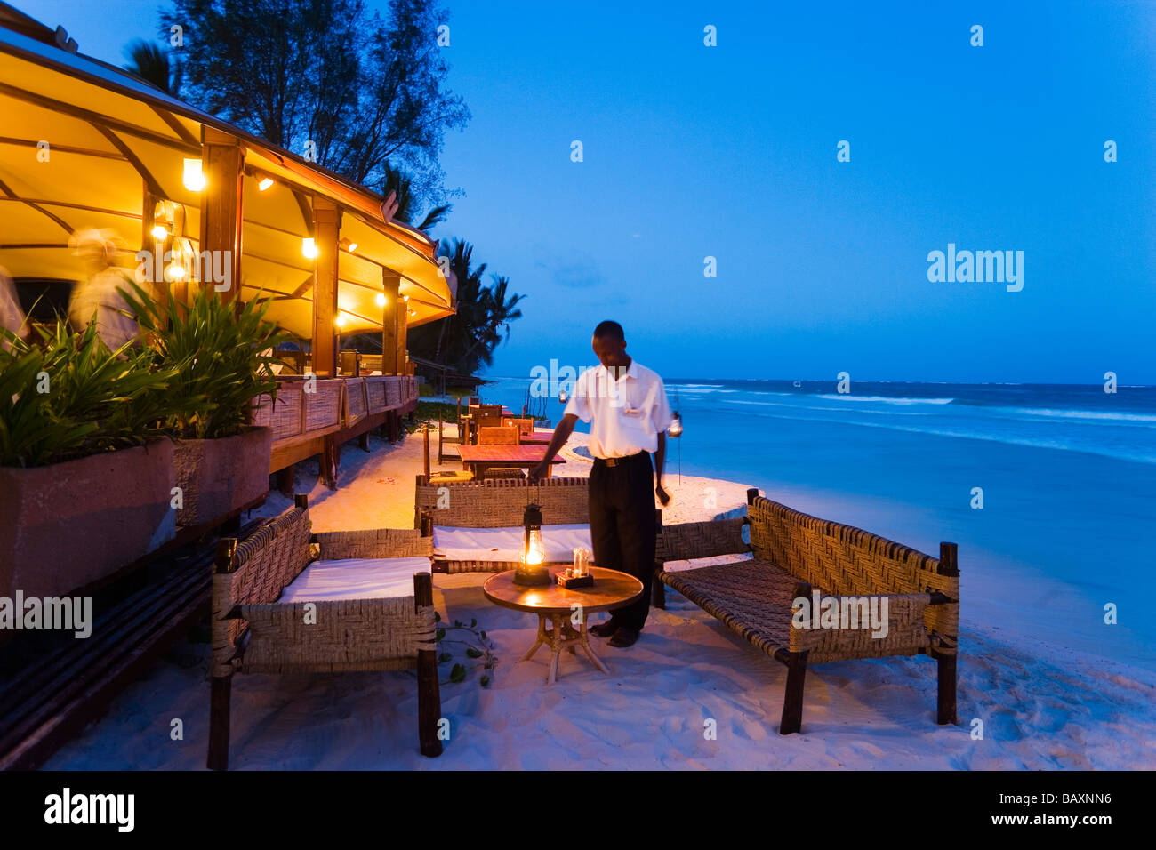 Waiter arranging lanterns, The Sands, at Nomad, Diani Beach, Kenya Stock Photo