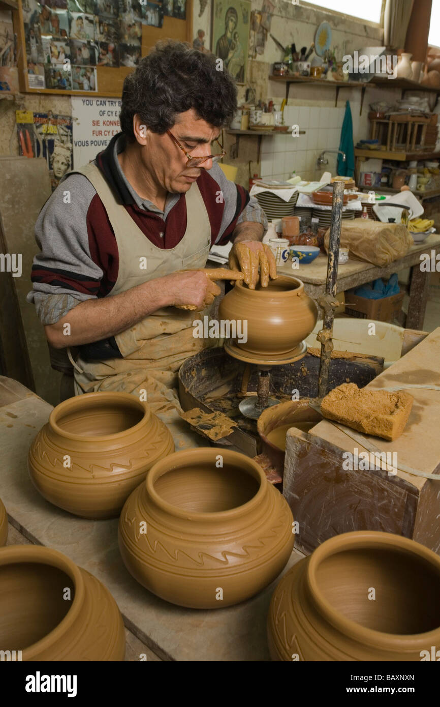 Craftsman in his at the potters wheel, making ceramic pottery