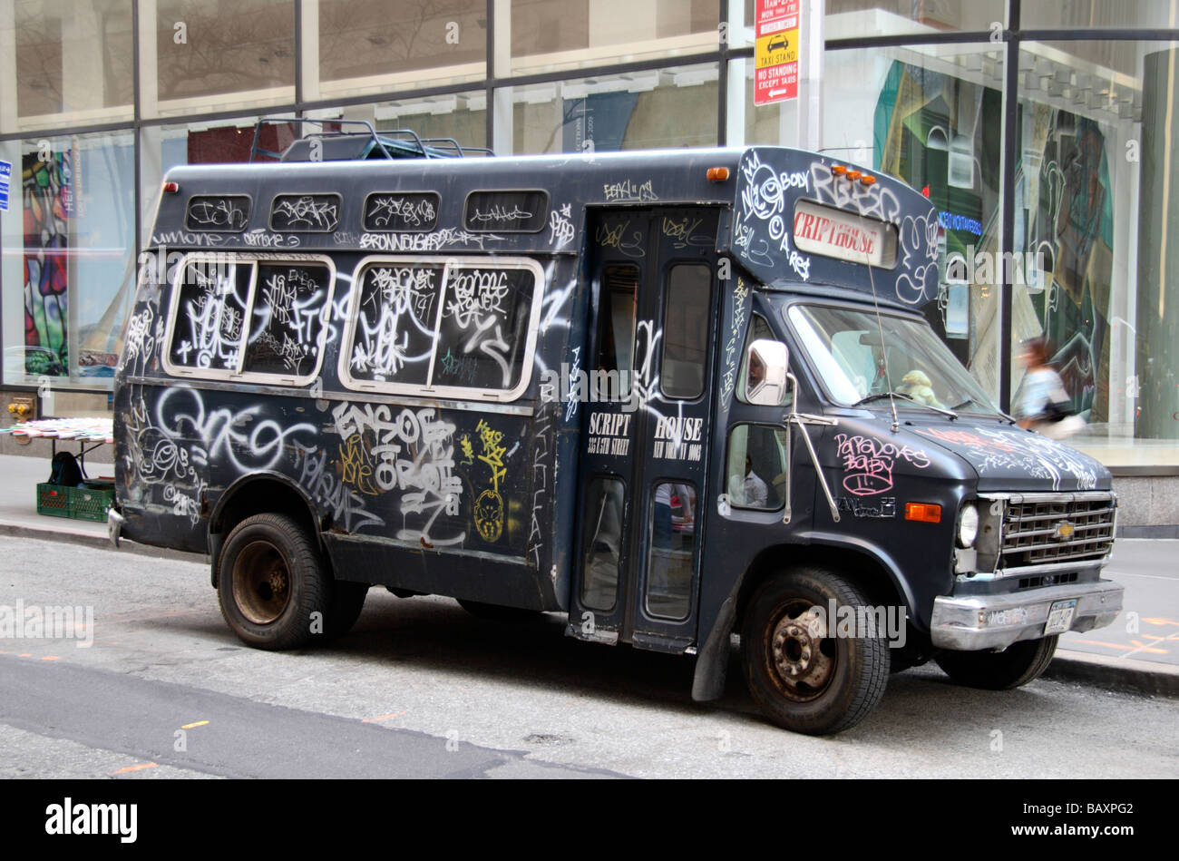 A graffitti covered mini bus sitting on a street in New York. Stock Photo