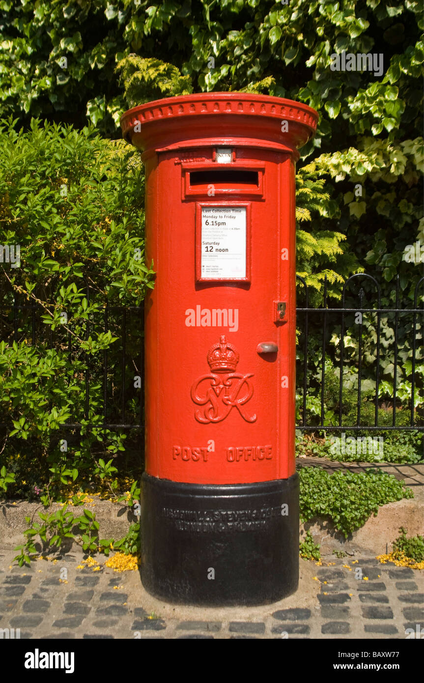 Vertical close up of an iconic red British pillar box - a free standing type A model from the reign of King George VI. Stock Photo