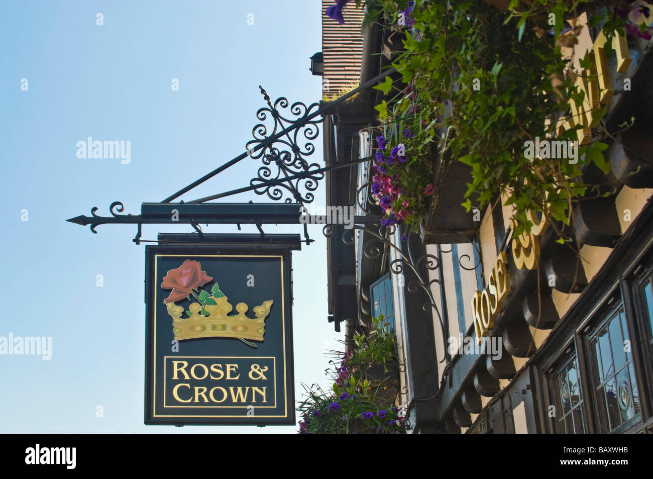 Horizontal close up of a traditional old wrought iron [Rose and Crown] pub  sign hanging against a bright blue sky Stock Photo - Alamy
