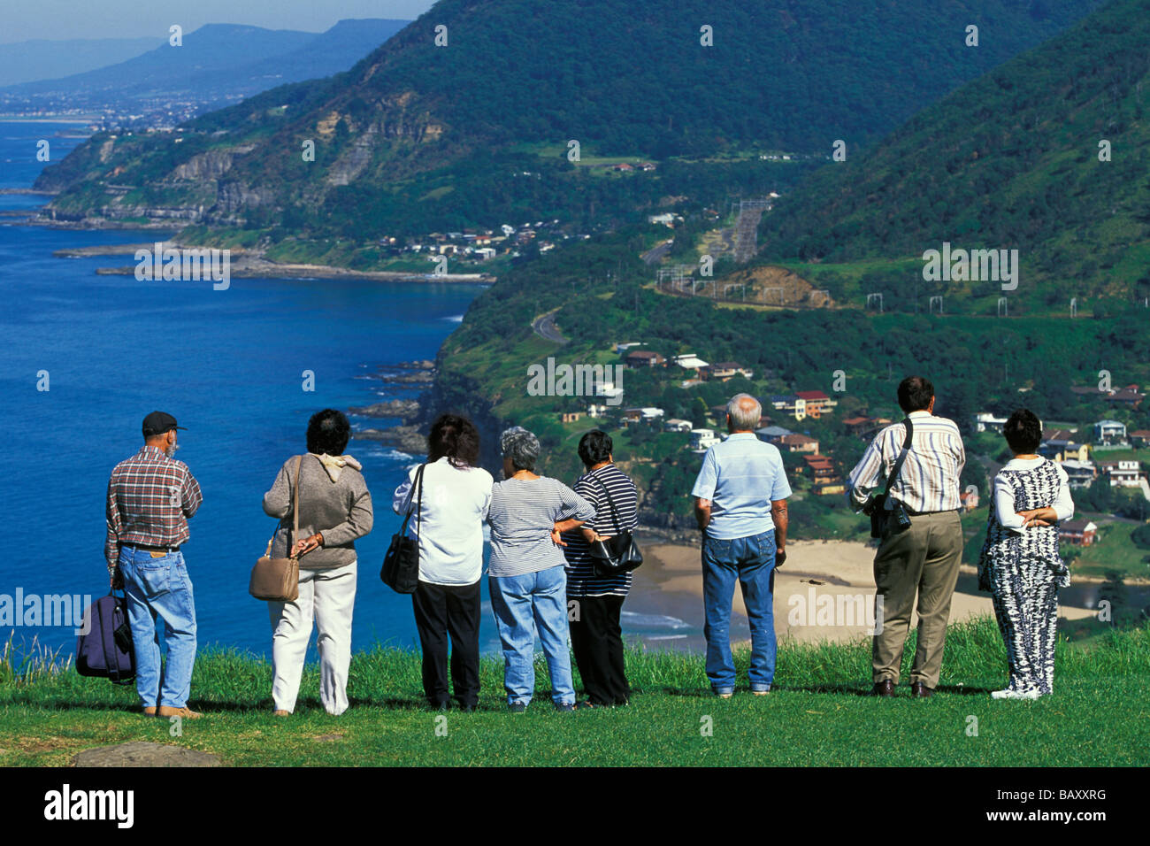 Sightseers looking from Bald Hill across Stanwell Park beach to the Illawara Escarpment and Wollongong New South Wales Australia Stock Photo