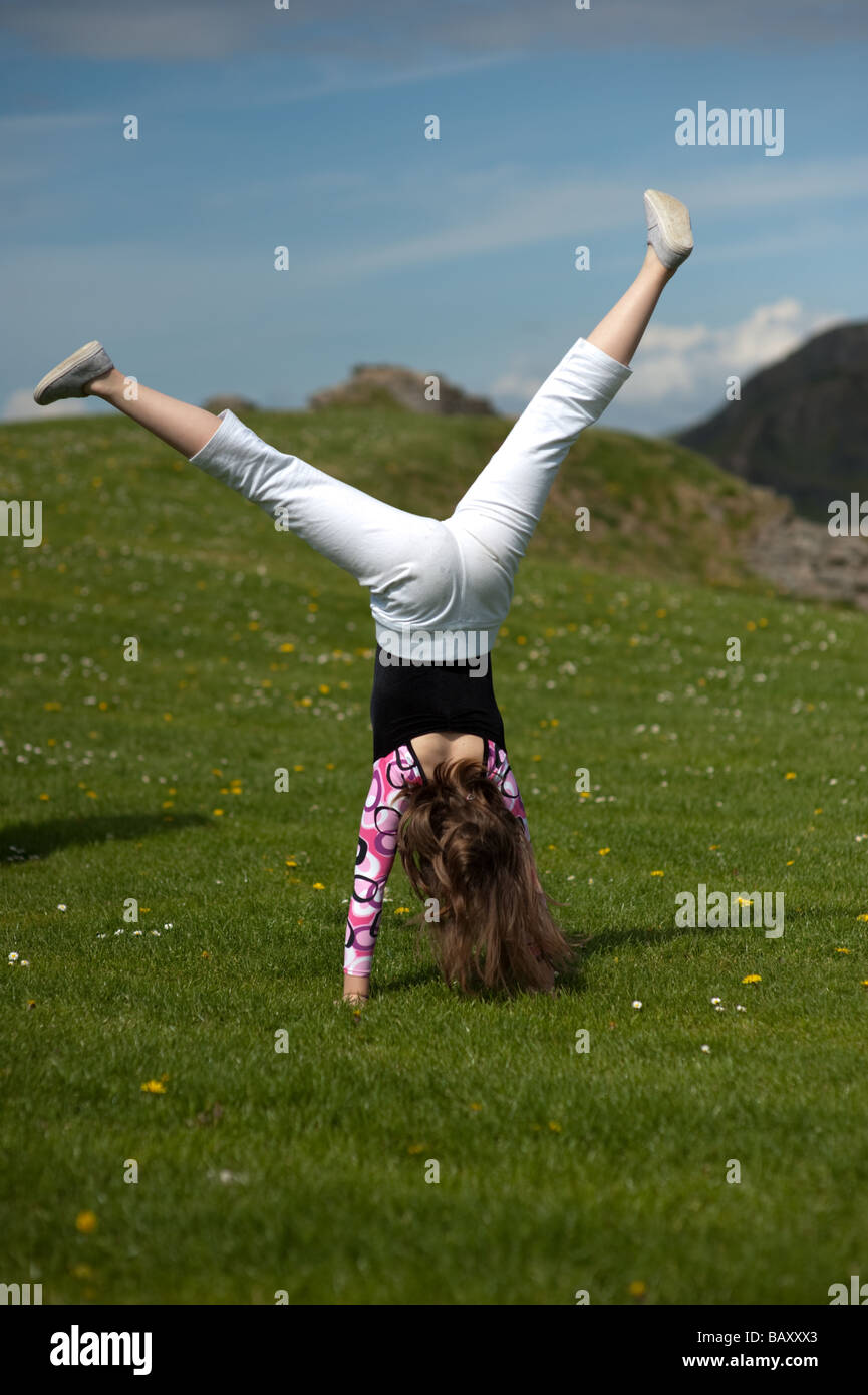 a-young-girl-doing-a-somersault-handstand-cartwheels-on-the-grass