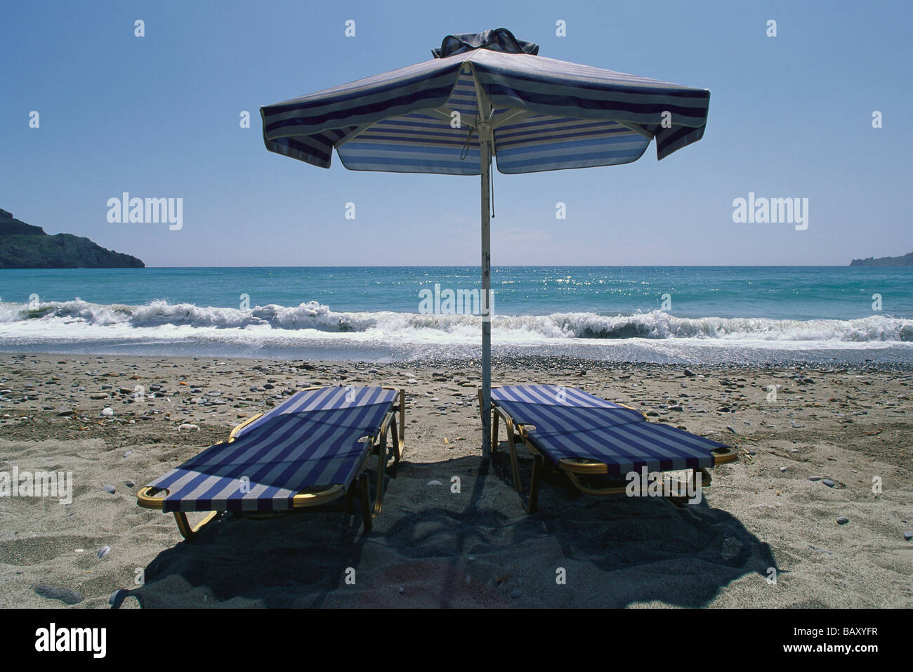 Two sun loungers and a sunshade on Plakias beach, Crete, Greece Stock Photo