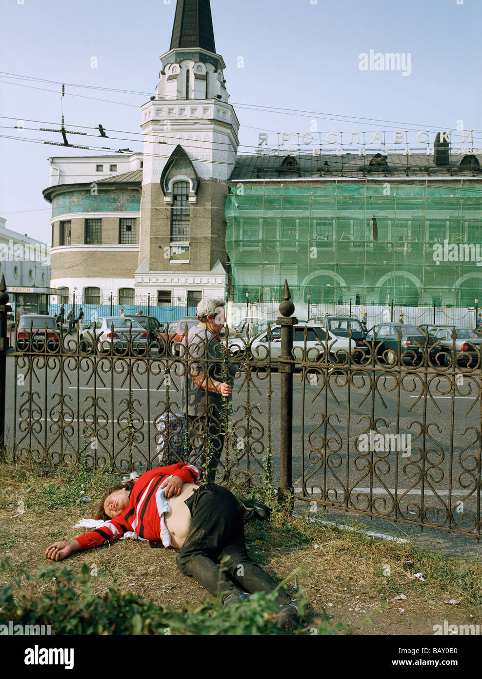 A man lying on the ground, in the background the Yaroslav railway station, Moscow, Russia Stock Photo