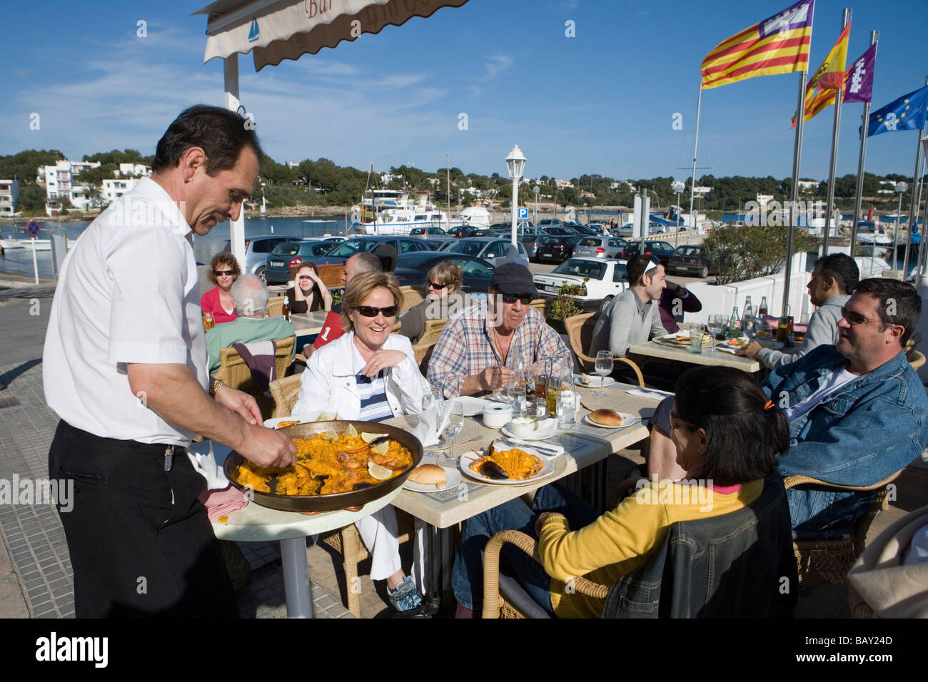 Waiter Serving Paella at La Caracola Restaurant, Portocolom, Mallorca