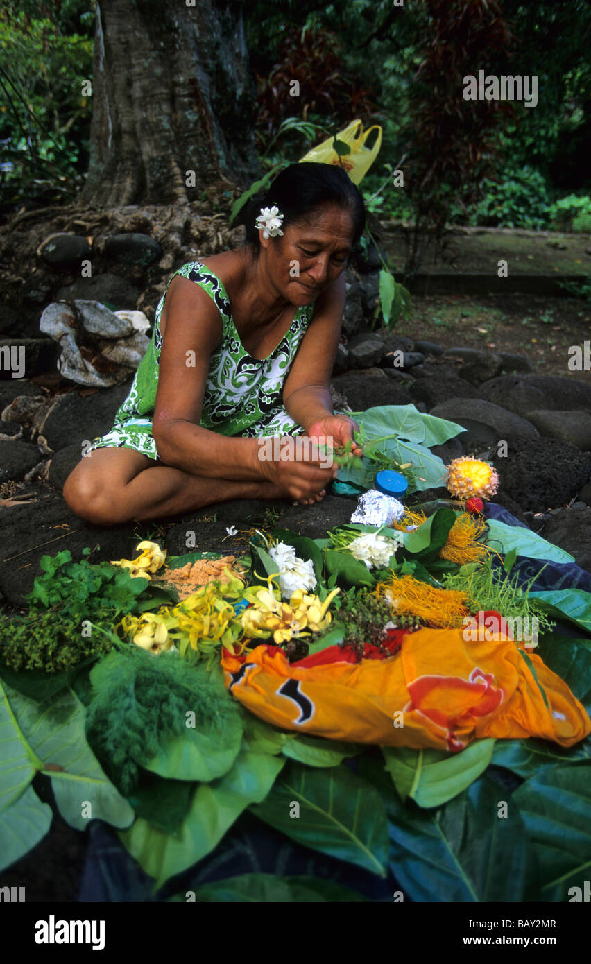 A native woman binding bouquets of flowers in the village of Omoa, island of Nuku Hiva, French Polynesia Stock Photo