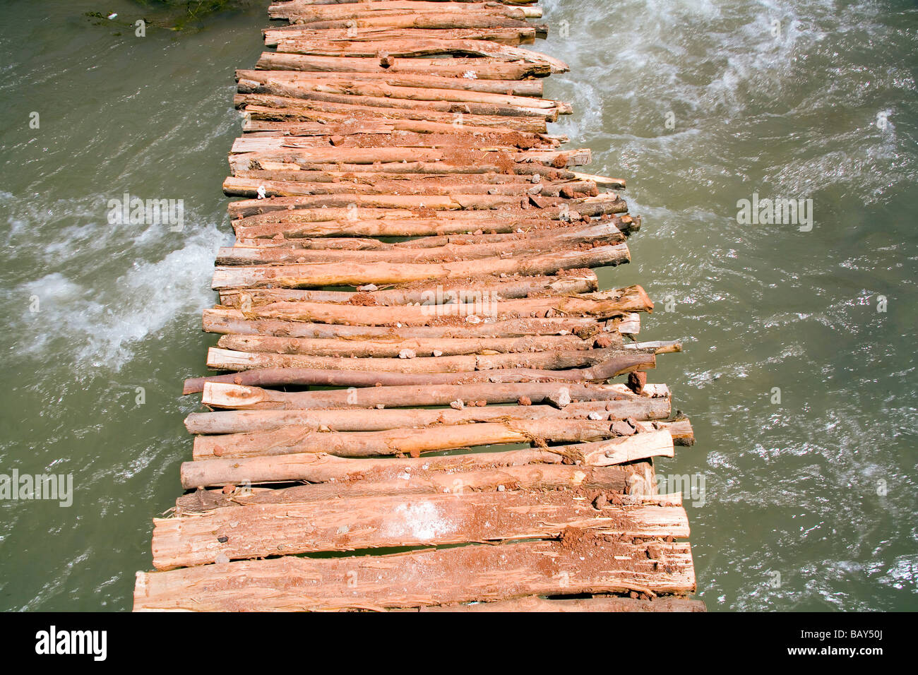 Makeshift wooden bridge over water Stock Photo - Alamy