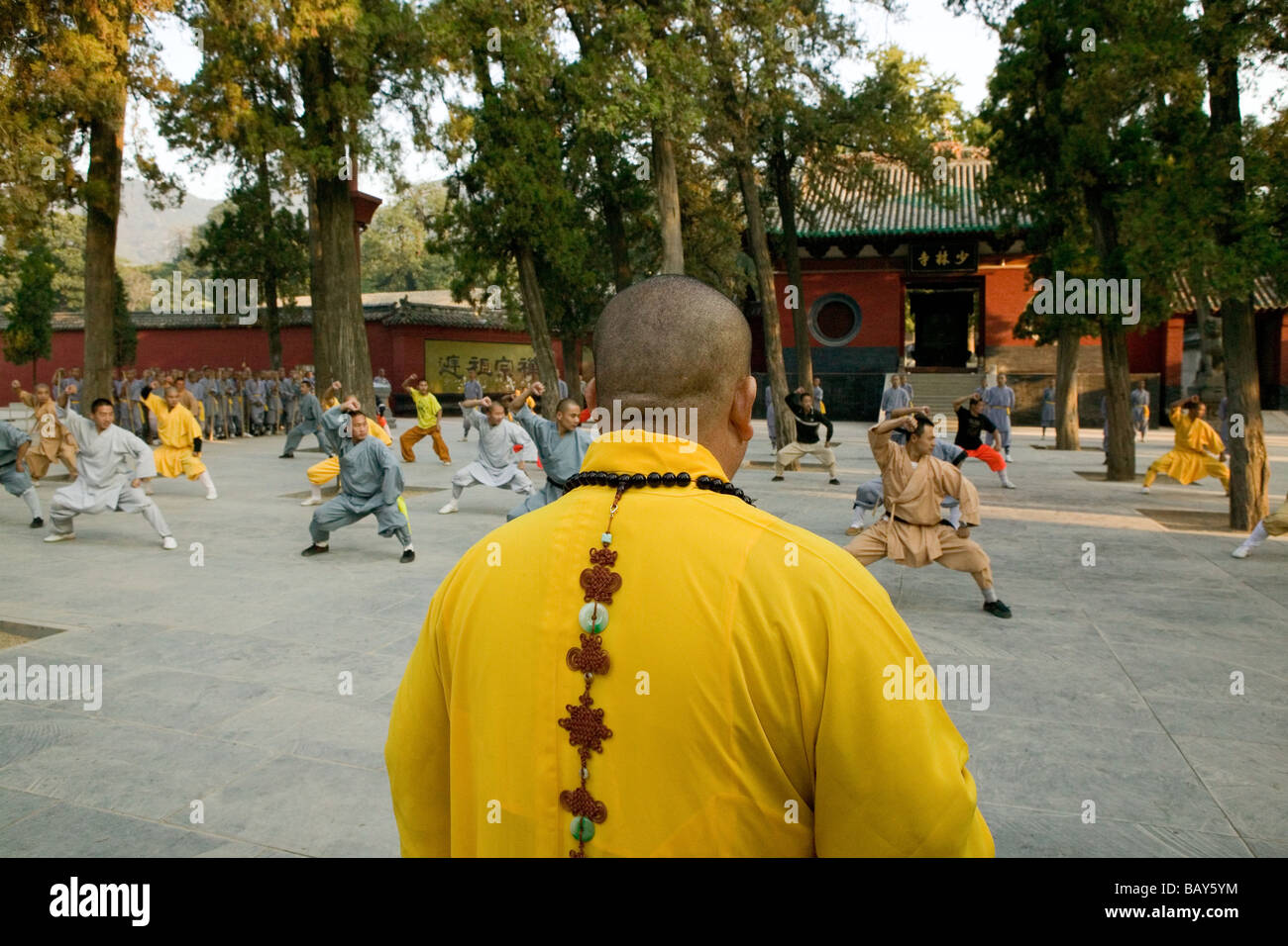 Shaolin Buddhist monk watching Kung Fu students, Shaolin Monastery known for Shaolin boxing, Taoist Buddhist, Song Shan, Henan p Stock Photo