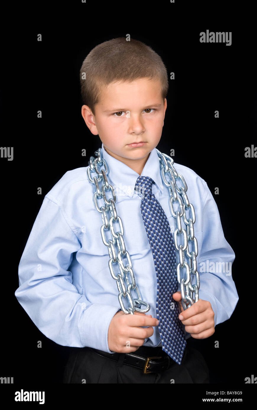 A young boy in a dress shirt and necktie has a chain around his