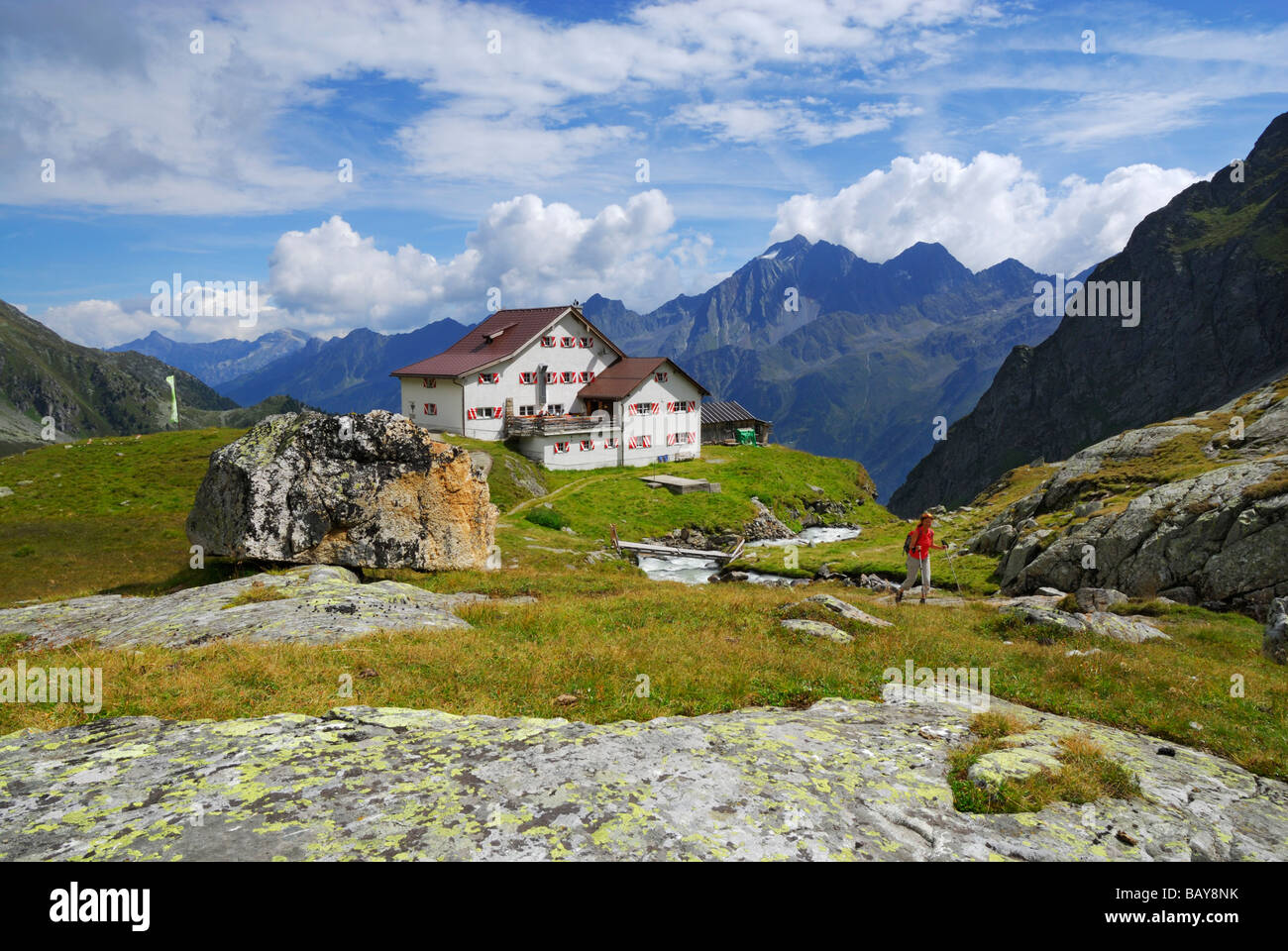 hiker in front of hut Neue Regensburger Huette with Habicht, Stubaier Alpen range, Stubai, Tyrol, Austria Stock Photo