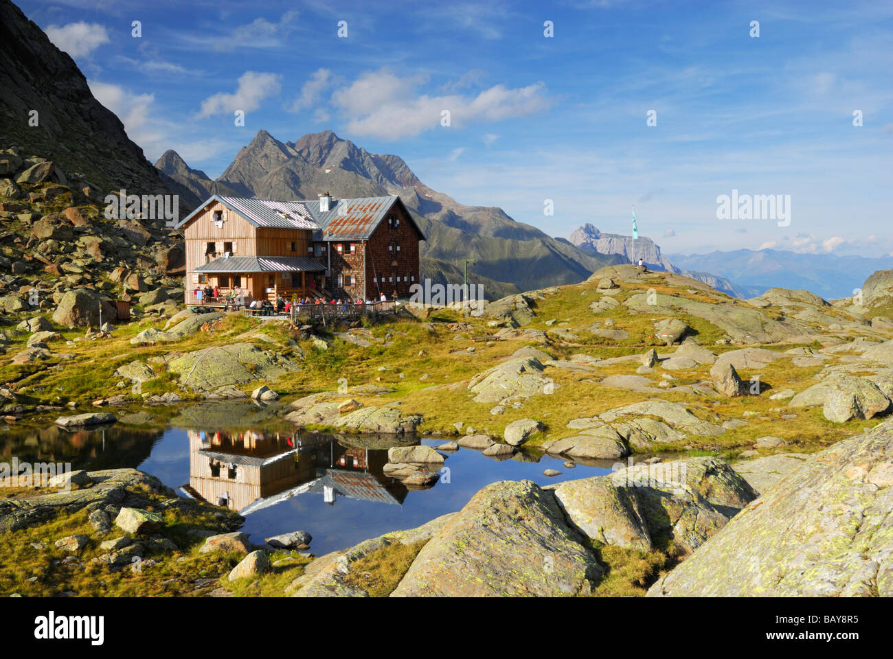 hut Bremer Huette and reflections in little lake, Habicht in background, Stubaier Alpen range, Stubai, Tyrol, Austria Stock Photo