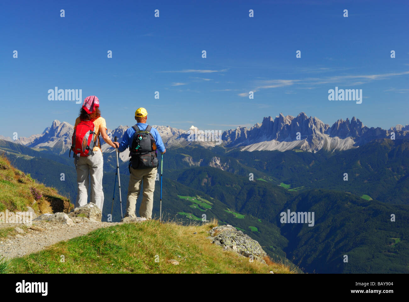 couple on trail with view to Dolomites with Peitlerkofel and Geislergruppe range, hut Radlseehuette, Sarntaler Alpen, Sarntal ra Stock Photo