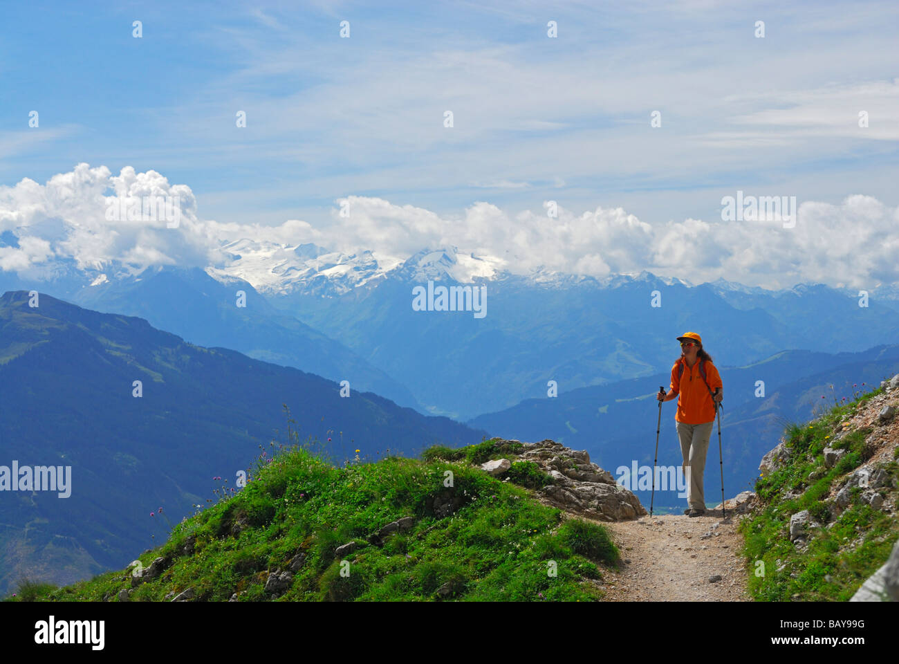 young woman on trail above valley of Maria Alm with view to Hohe Tauern range, Steinernes Meer range, Berchtesgaden range, Salzb Stock Photo