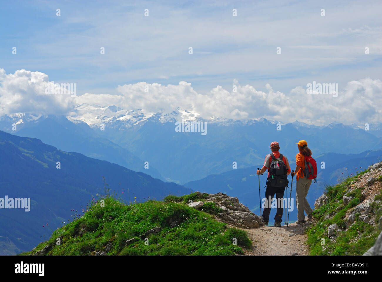 couple on trail above valley of Maria Alm with view to Hohe Tauern range, Steinernes Meer range, Berchtesgaden range, Salzburg, Stock Photo
