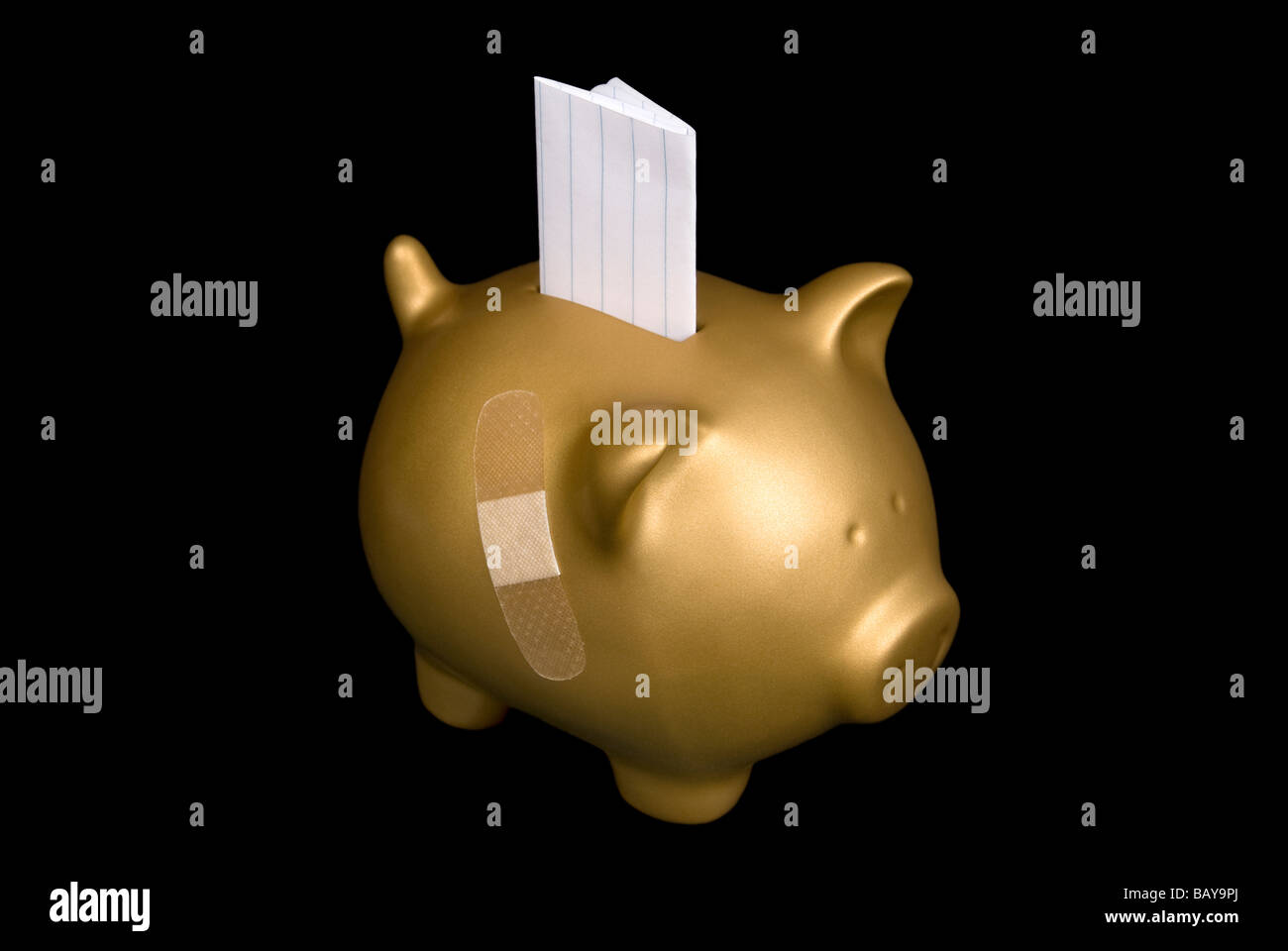 A slip of paper with copy space sticks out of a piggy bank that is financially wounded with a bandage Stock Photo