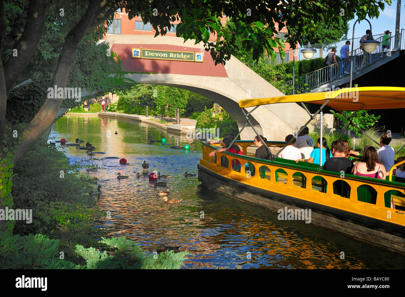 A water taxi carries visitors under the Devon bridge in Oklahoma City s Bricktown Stock Photo