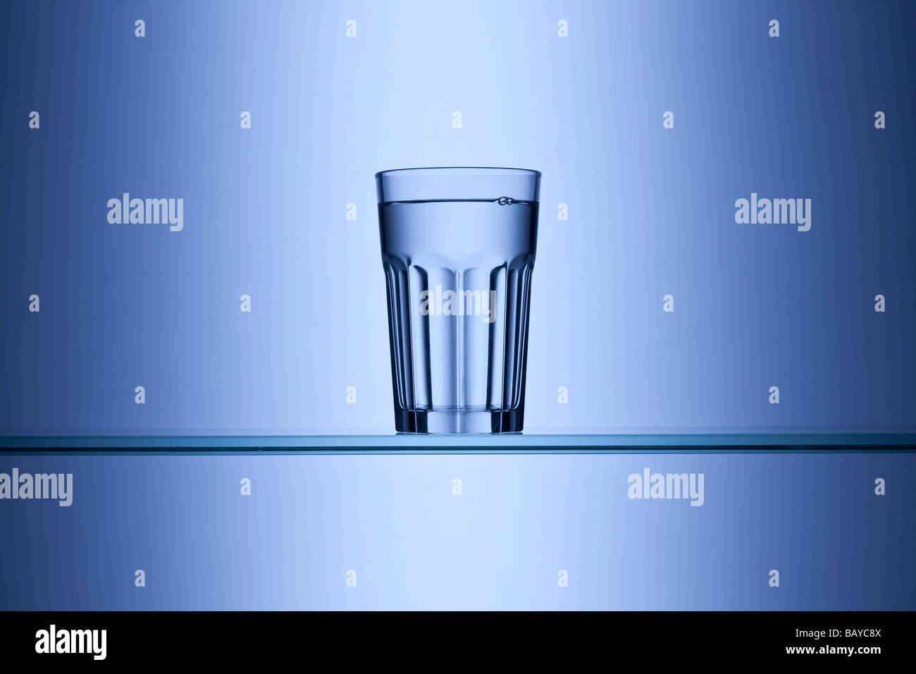 Glass of drinking water on blue background Stock Photo