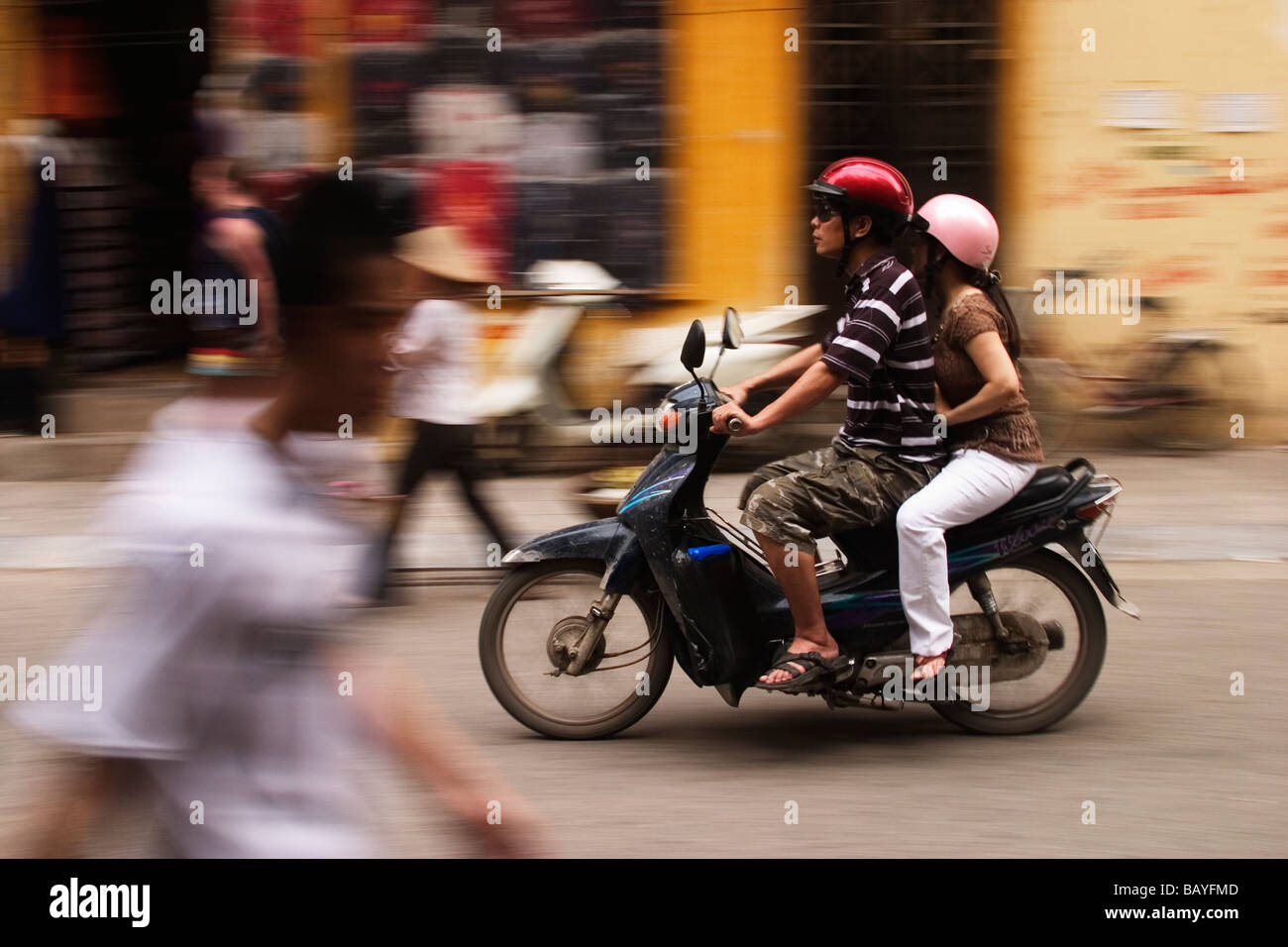 A motorbike whizzes down a street in Hanoi, Socialist Republic of Vietnam. Stock Photo