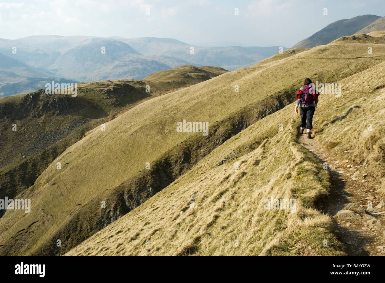 A female fell walker on a path beside Angletarn Pikes in the English