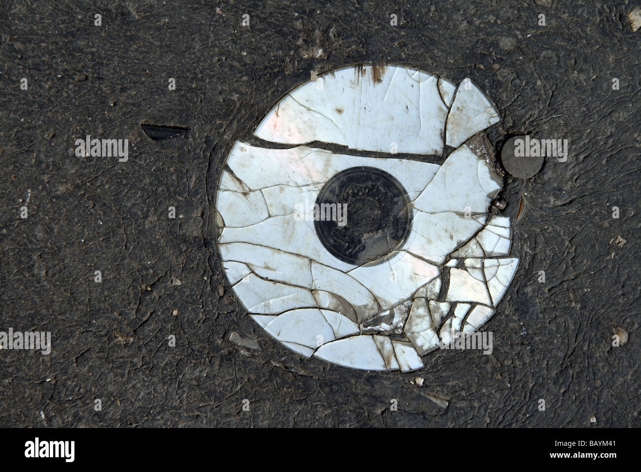 one old damaged cd compact disc disk on road surface Stock Photo