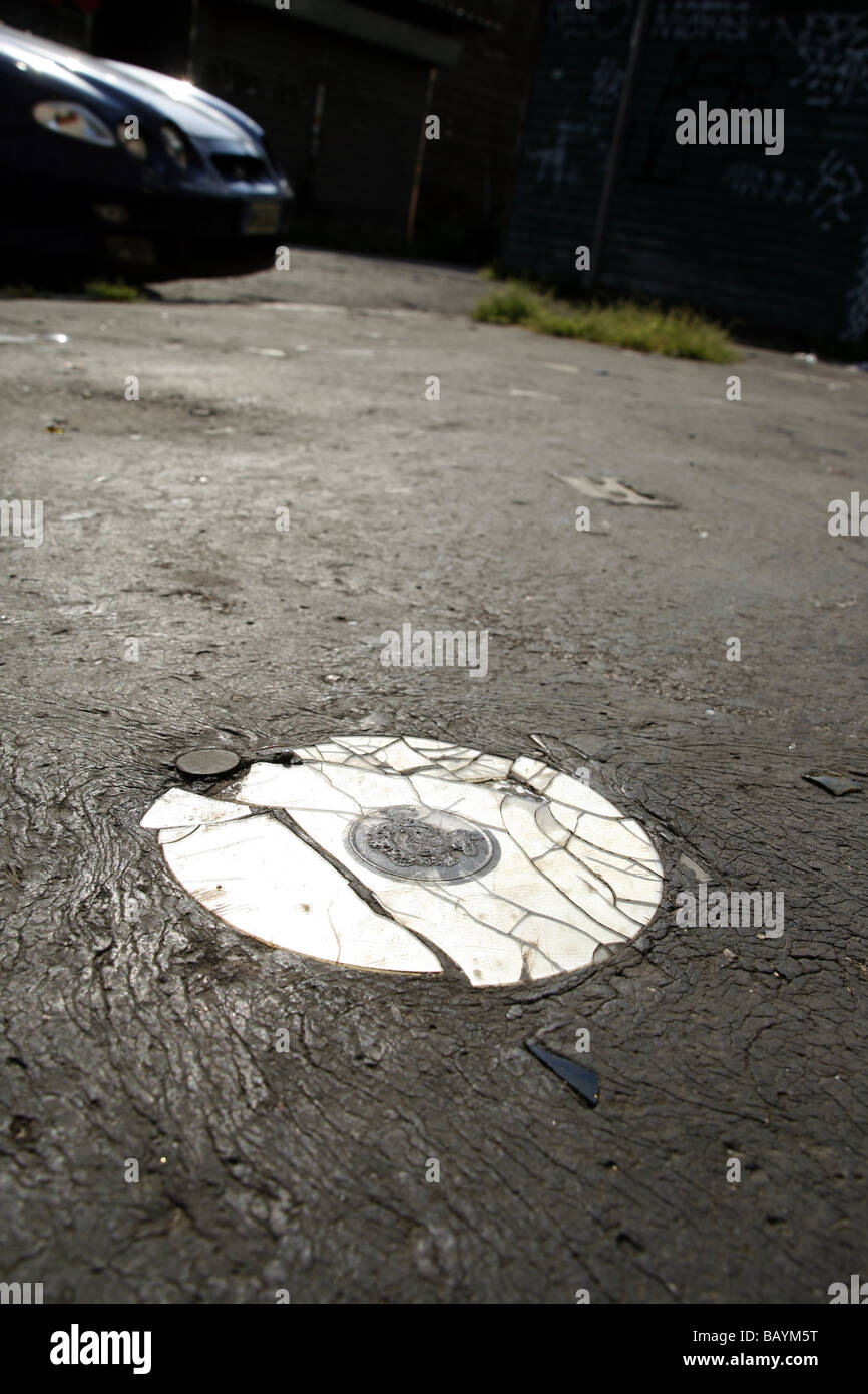 one old damaged cd compcat disc on road surface Stock Photo