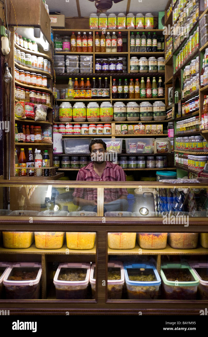 Small shop selling food and drinks, and the shop keeper, in Shimla
