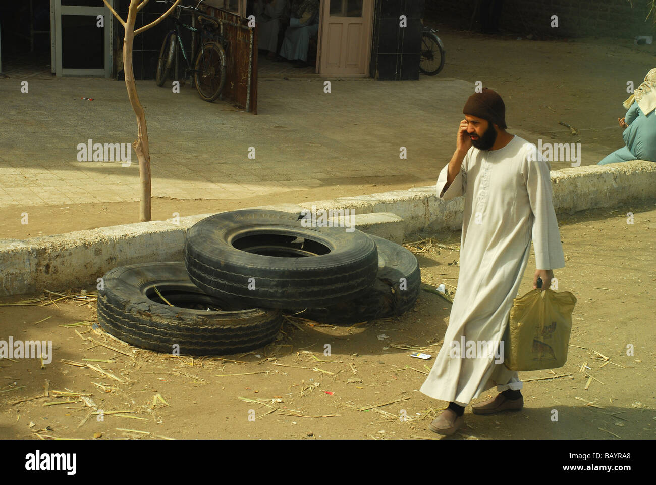 Egyptian man walking along with a cell phone in a village in Egypt