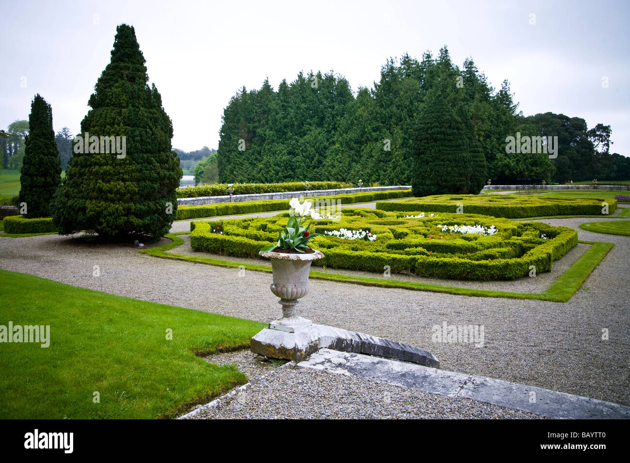 Landscaped grounds flowers urns and hedges of the Adare manor house in