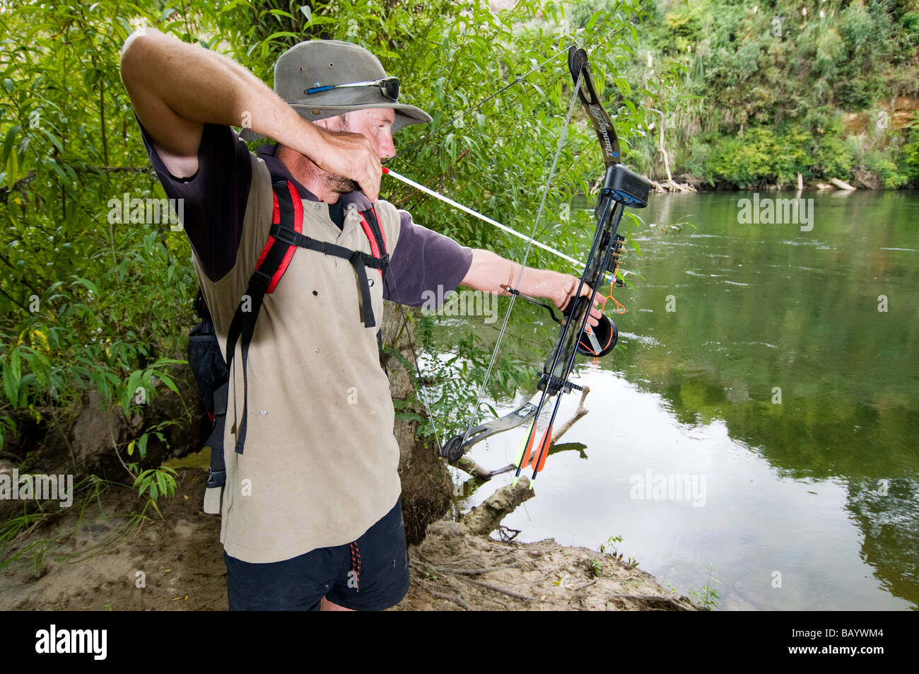 man hunting fish with bow and arrow attached to string Stock Photo