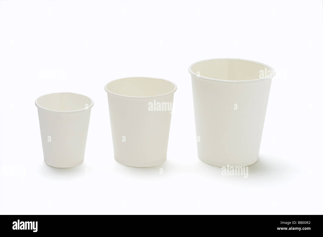 Three assorted sizes disposable paper cups on white background Stock