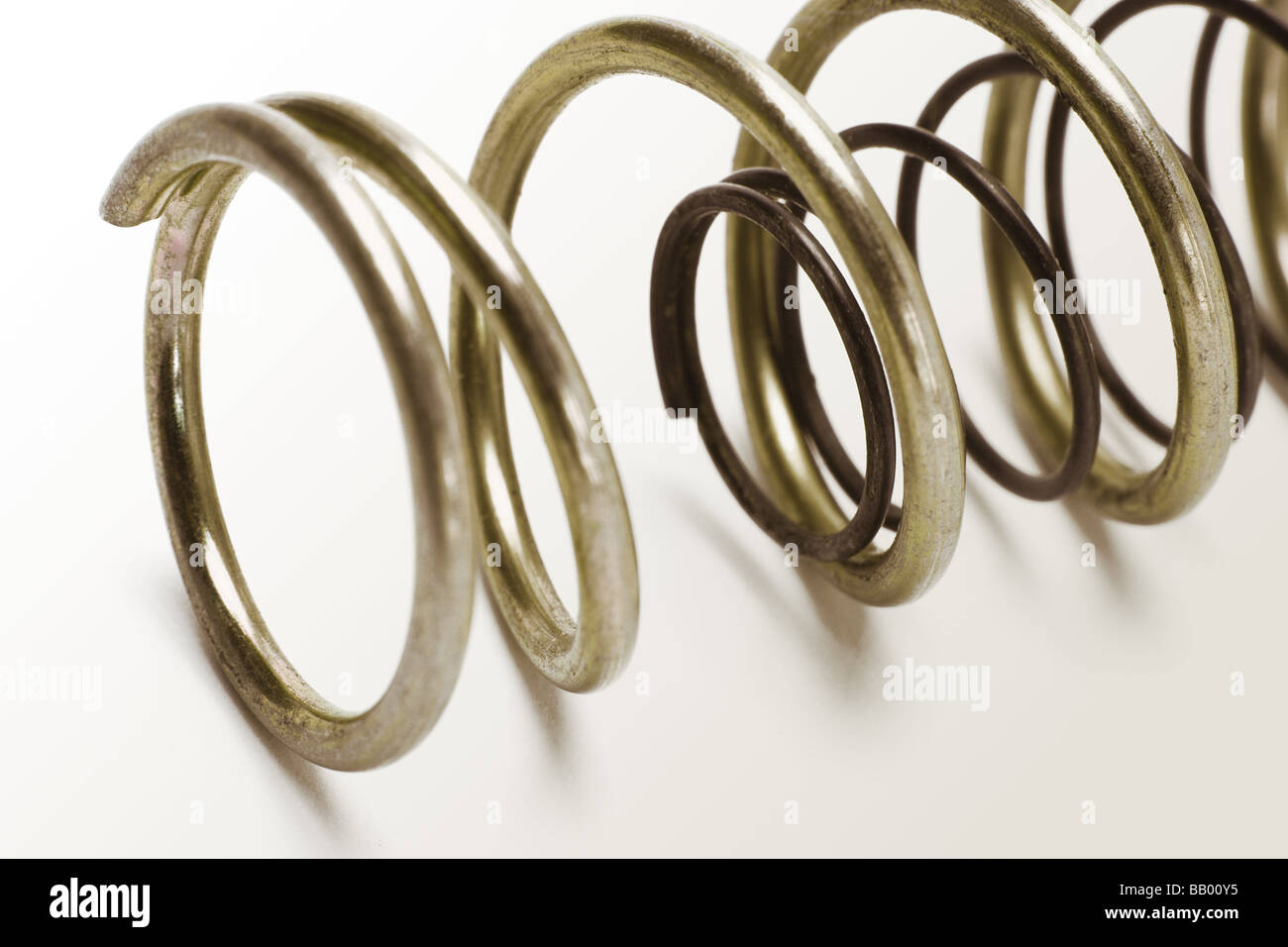 Metal spring coils of different sizes one inside another Stock Photo