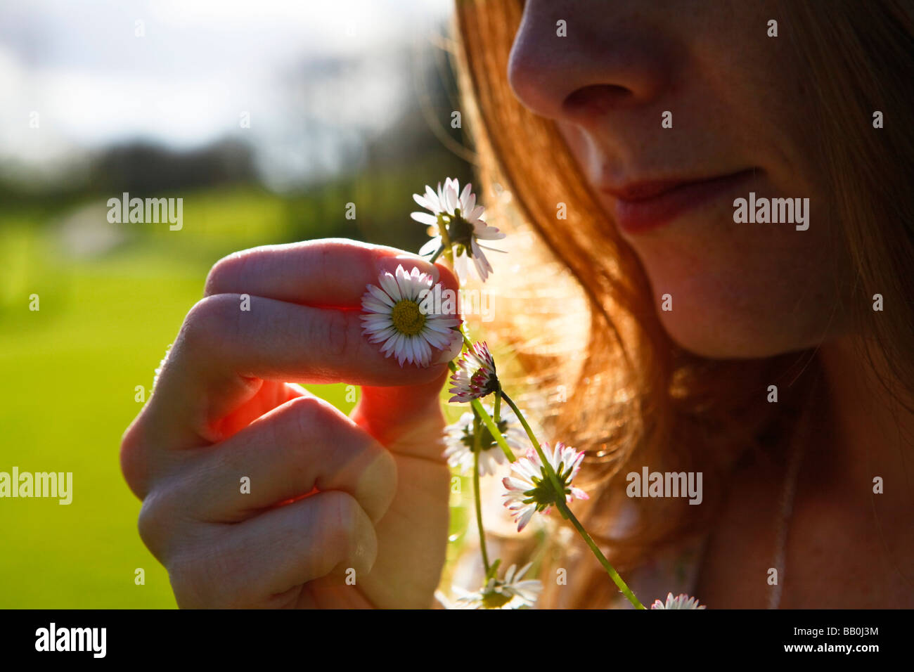 woman holding a daisy chain in the sunshine. Stock Photo
