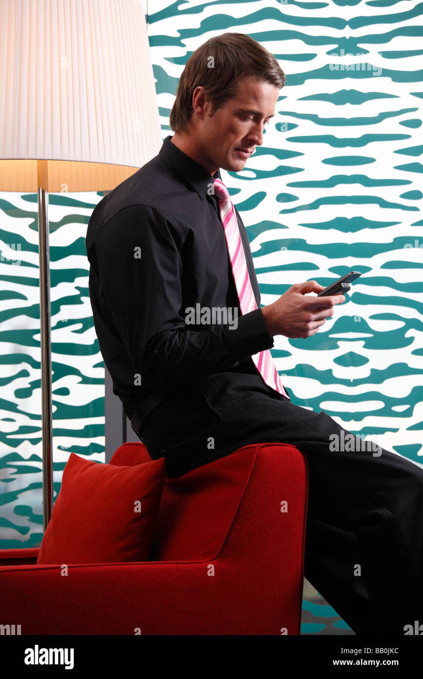 Professional man on his mobile phone in a hotel room. Stock Photo