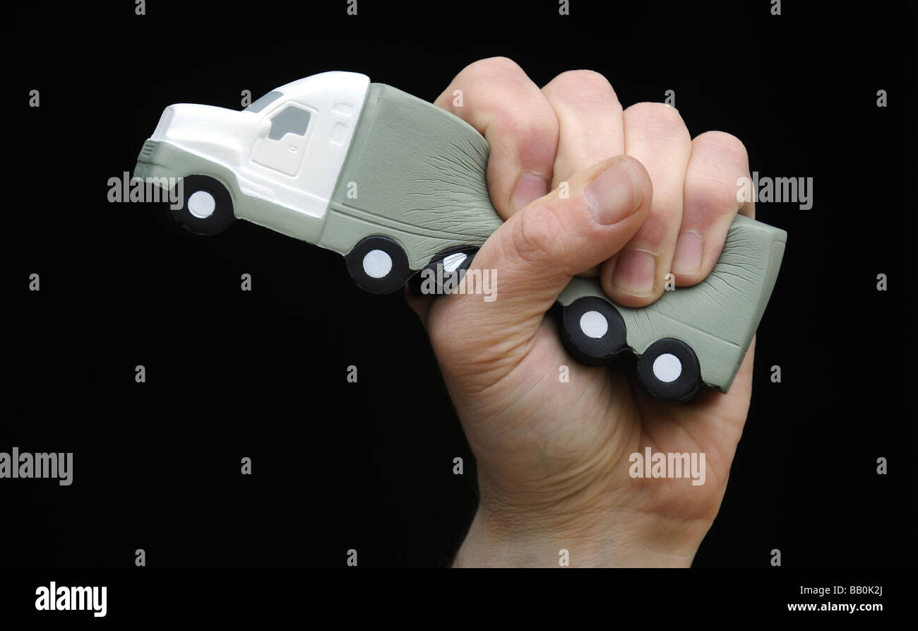 A HGV LORRY GRIPPED AND SQUEEZED IN A MANS HAND,ILLUSTRATING  THE ECONOMIC SITUATION IN THE BRITISH HAULAGE TRADE,UK. Stock Photo