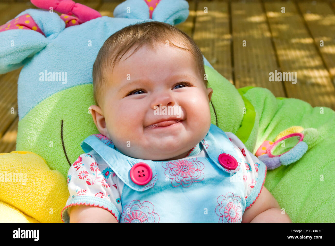 Horizontal close up portrait of a six month old baby girl laughing and