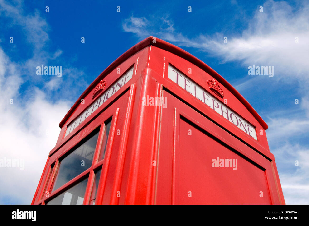 An iconic red British telephone box contrasted against a blue sky and white clouds Stock Photo