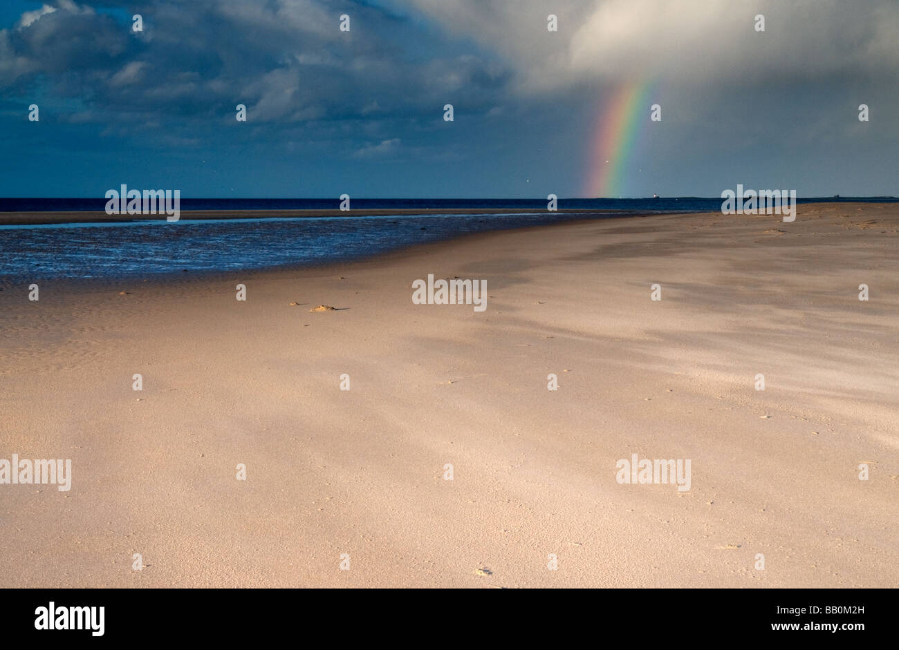 Rainbow at Budle bay overlooking Inner Farne islands and Lighthouse Stock Photo