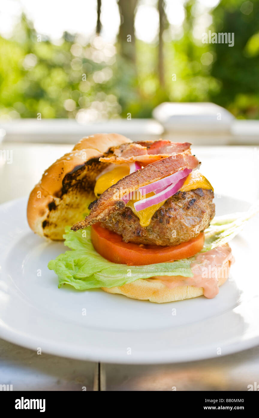 An American classic bacon cheeseburger fresh from the grill sits on a plate Stock Photo