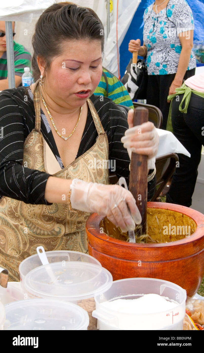 Woman preparing a Hmong Asian specialty food in a mortar and pestle. Hmong Sports Festival