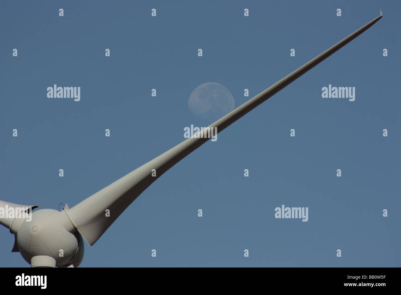 The moon rolls down the blade of a wind turbine at mt millar in south Australia Stock Photo