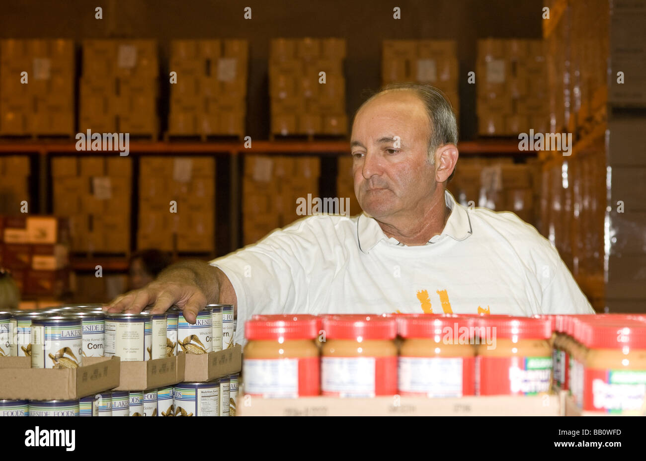 A man organizes cans in the warehouse of the California Food Bank in