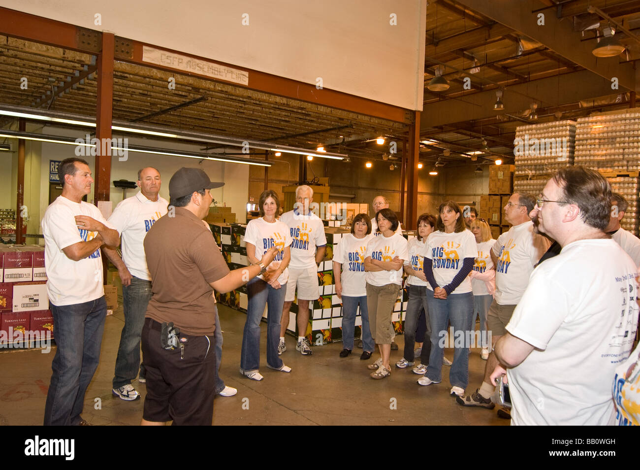 A staff member talks to volunteers in the warehouse of the California