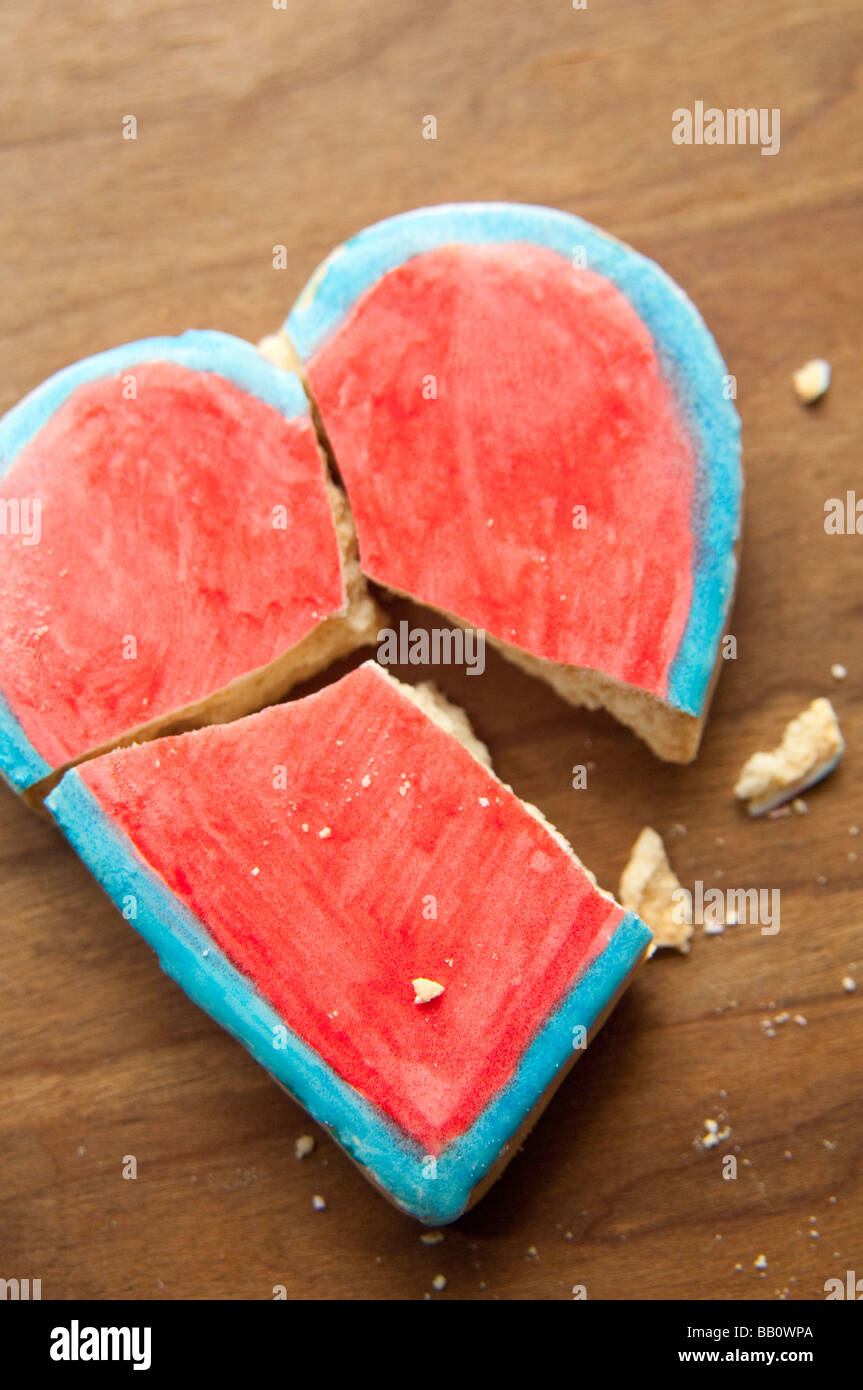 Broken heart-shaped Valentine cookie with crumbs. Stock Photo