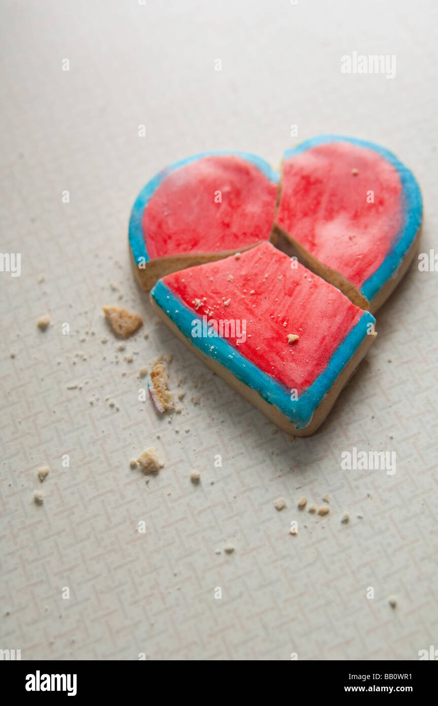 Broken heart-shaped Valentine cookie with crumbs. Stock Photo