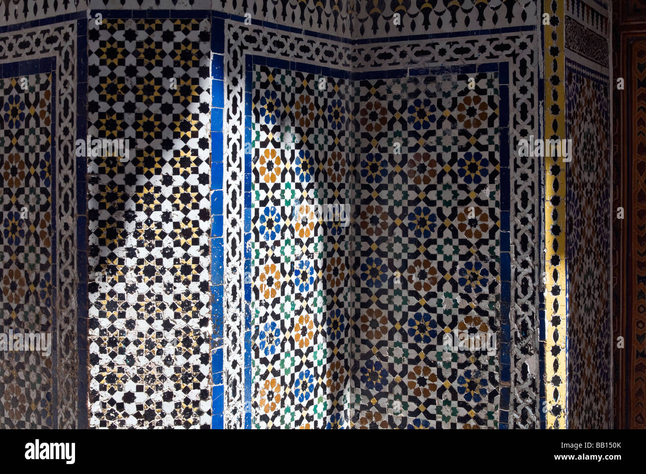 Wall of beautiful blue, white, yellow-ochre, and black coloured Moroccan, mosaic, Zellige tiles in Fes, Morocco. Stock Photo