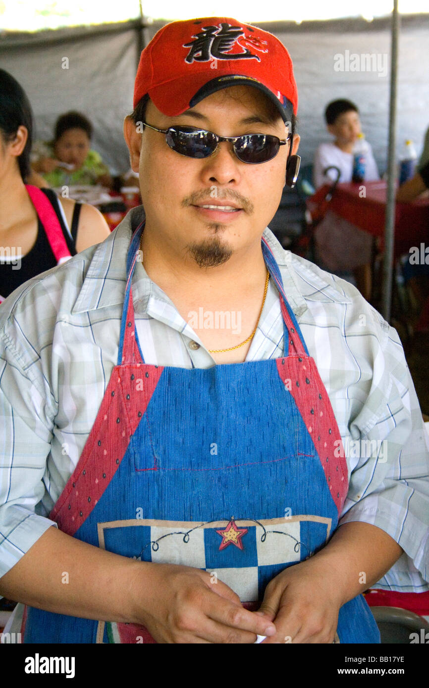 Hmong cook in outdoor restaurant wearing colorful apron and cap. Hmong ...