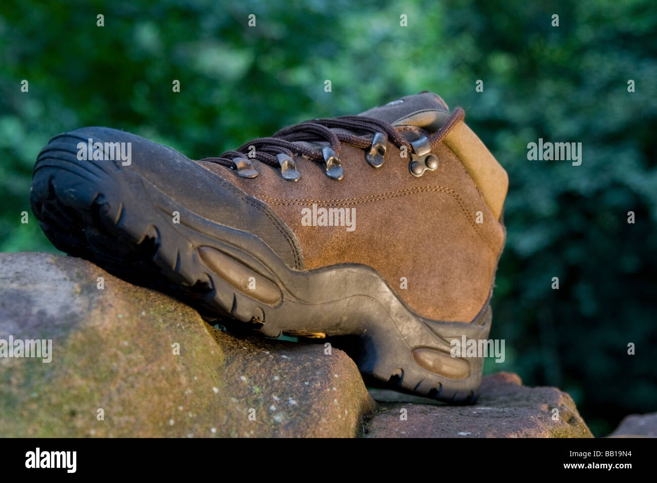 Single hiking boot on rock Stock Photo