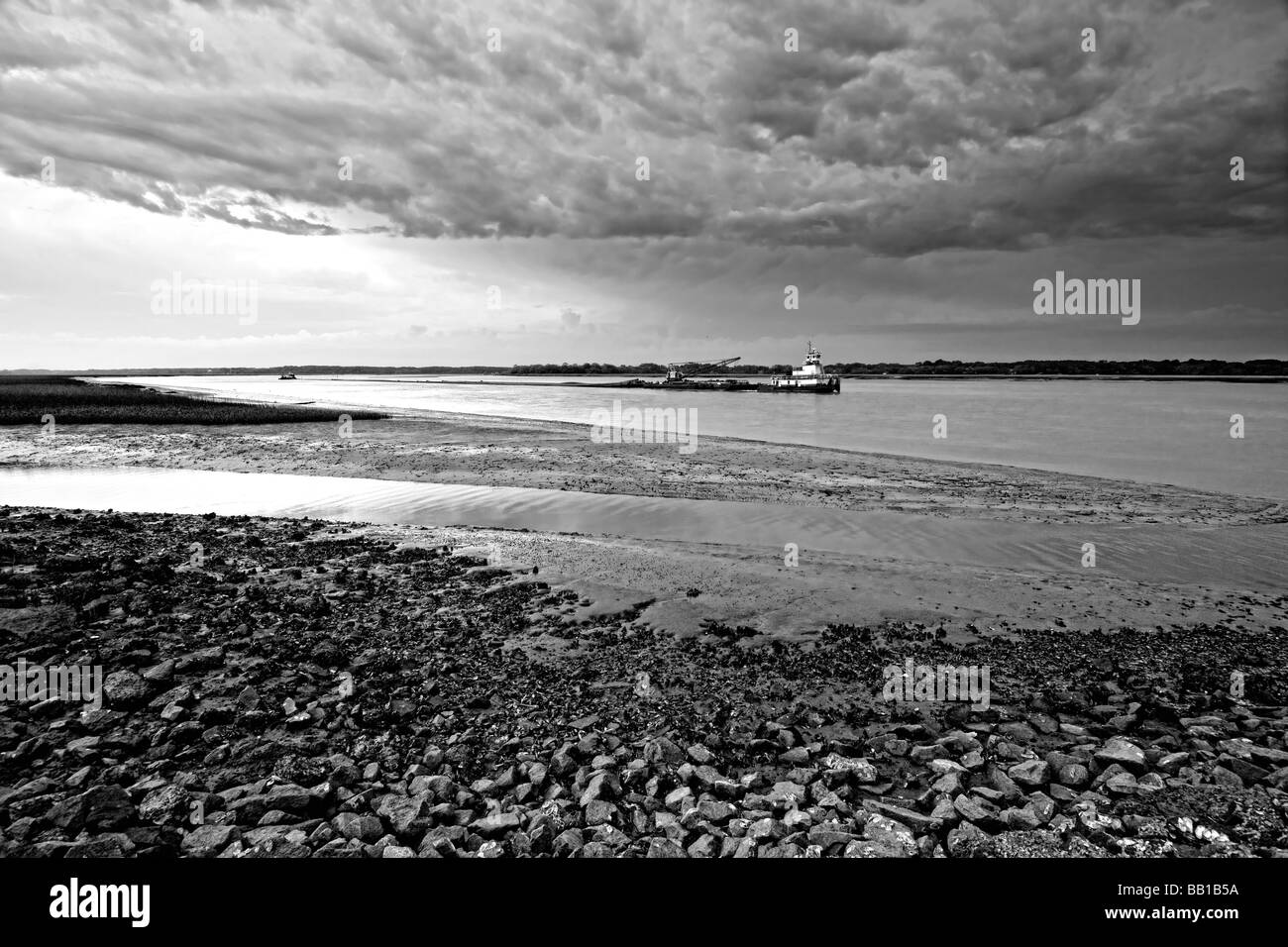 tug boat going by during angry weather at low tide Stock Photo